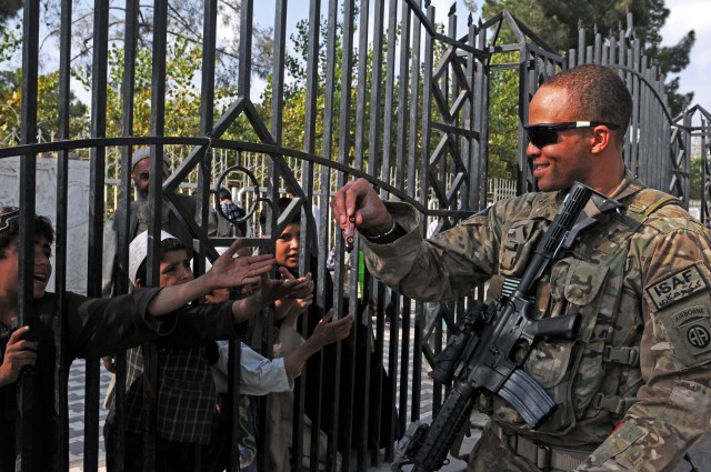 82nd Airborne Division Soldier hands out toys to Afghan children