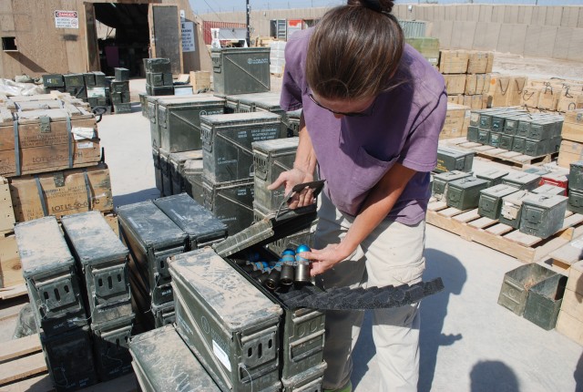 Suzanne Greenway breaks down pallets of ammunition at Camp Liberty, Iraq.