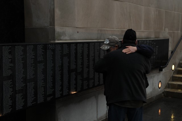 Vietnam Veterans embrace in front of the Chicago Vietnam Veteran's Memorial