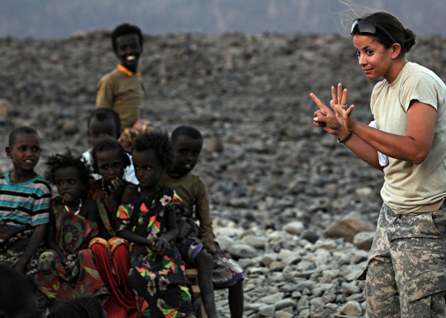 KARABTI SAN, Djibouti - U.S. Army Specialist Tiffany Larriba, Civil Affairs Team 4902, 490th Civil Affairs Battalion team member, laughs as her hat is pulled over her eyes by a local boy at Karabti Sa