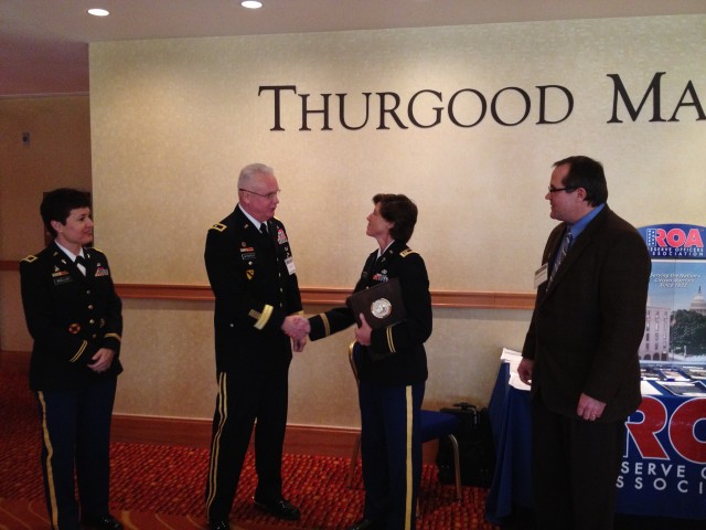 Chaplain (Capt.) Karen A. Hallett receives coin from Brig. Gen. Douglas R. Satterfield