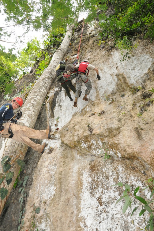 Soldiers as they prepare to rappel down the side of a cliff during a simulated high angle casualty evacuation
