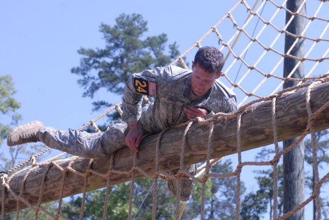 Staff Sgt. Samuel Leritz, Team 24, negotiates the cargo net on the obstacle course at Darby Queen.