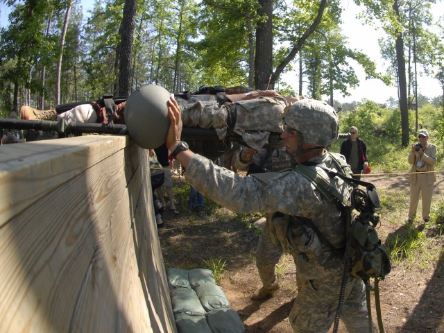 Army Staff Sgt. Matt Madiar and Sgt. 1st Class Zach Phillips maneuver a 180-pound