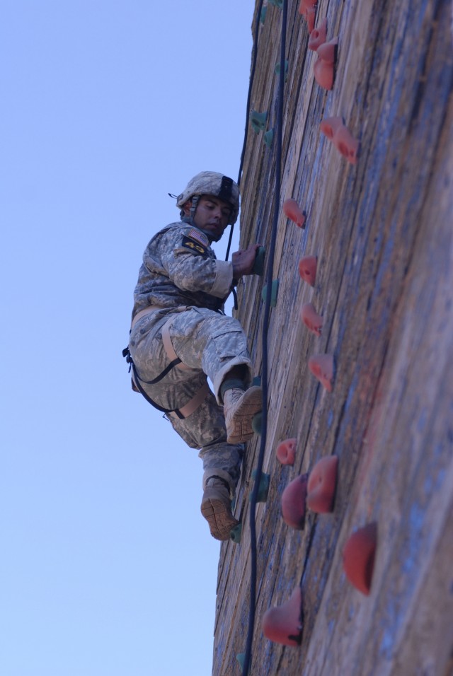 Army Sgt. 1st Class Vince Castellanos climbs the rock wall on the tri-tower during the Best Ranger Competition