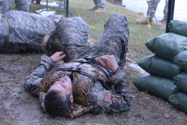 Team 21 member drops to the ground after completing the helocast and swim at Victory Pond