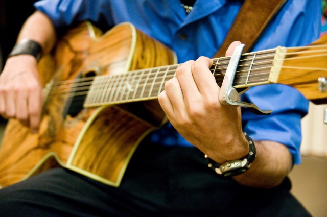A Soldier strums a guitar