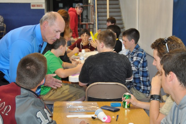 CAAA Judge explains rules to students at science fair