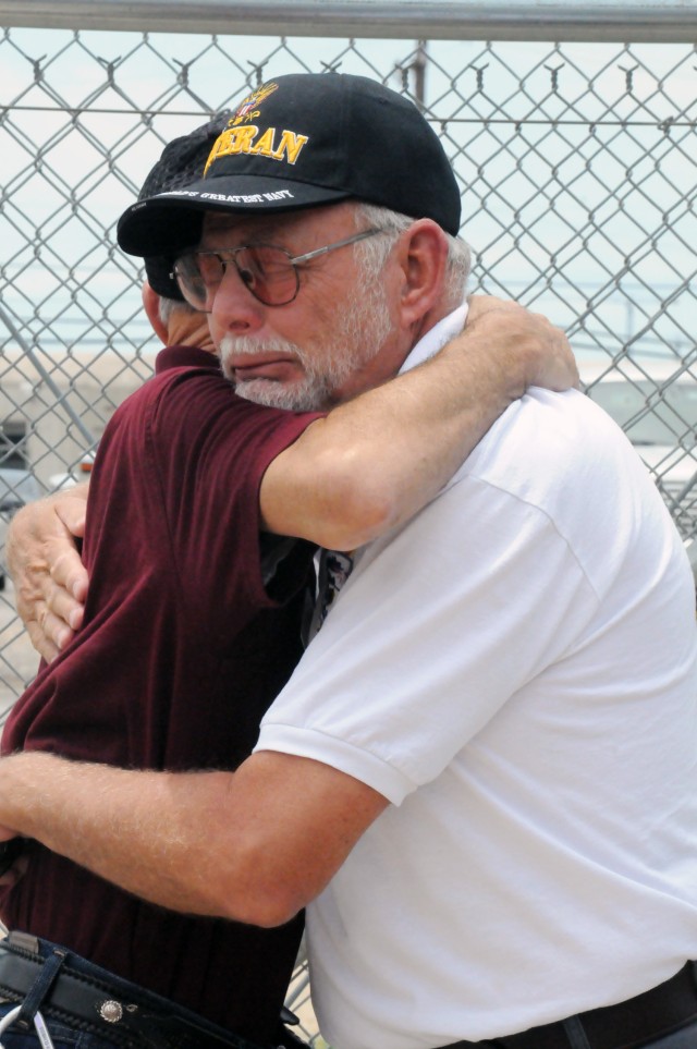 Brothers in arms -- Fellow former Navy door gunner Gary Ely embraces Craig Jones after Jones was belatedly award the Navy's Combat Aircrew wings for his service in Vietnam in 1969.