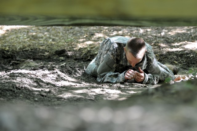 Drill Sergeant McQuiston low crawls an obstacle on confidence course at DSOY competition