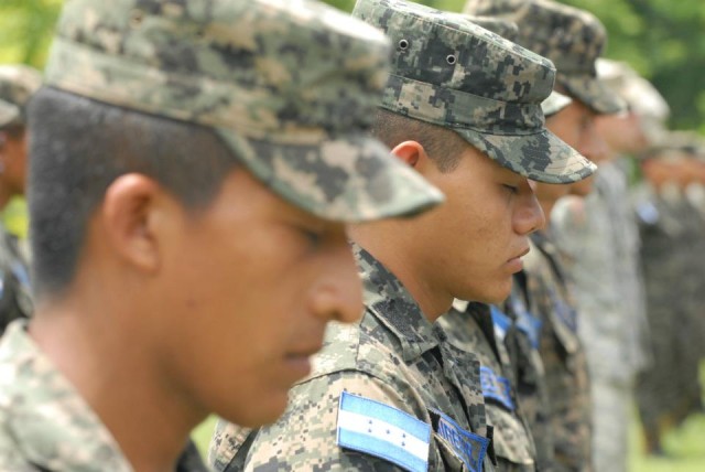 Honduran airmen bow their heads during a prayer at the closing ceremony for BTH-Honduras 2012.