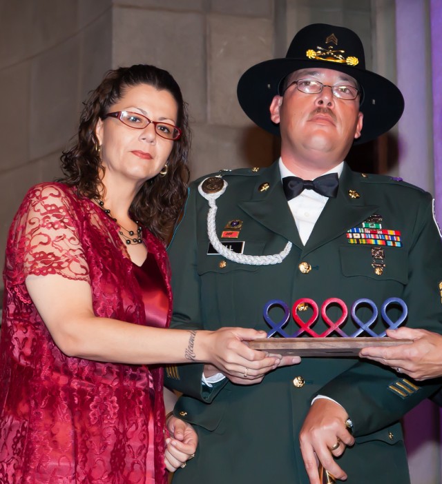 Noemy Hall and her husband Sgt. Richard Hall shows the Courageous Caregiver Award to attendees at the Got Heart, Give Hope® Gala in Washington, D.C.