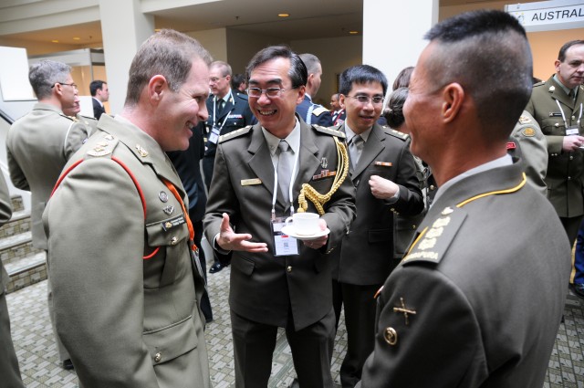 Australian Army officer speaks with Singaporean officers during a tea break