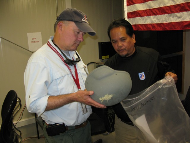 Dr. Obusek inspects a helmet used in combat