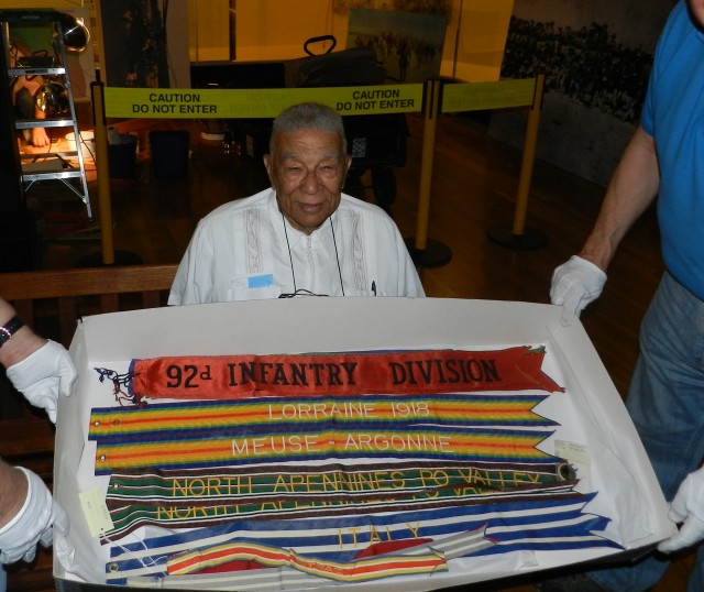 Retired Capt. Joseph Hairston poses with the unit streamers for the 92nd Infantry Division. Hairston was one of the first black officers commissioned to serve with the 92nd during World War II.