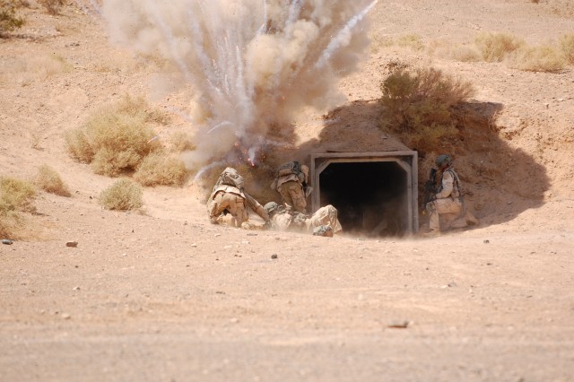 A simulated improvised explosive device explodes as Host Nation Security Forces replicated by the 11th Armored Cavalry Regiment enters a bunker as part of a training exercise at the National Training