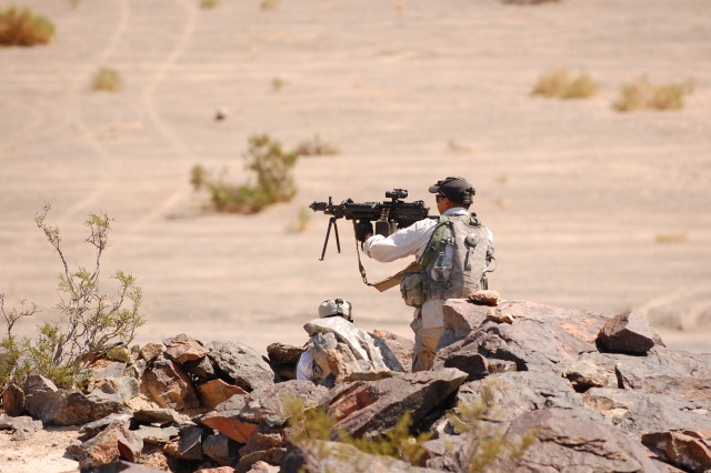 Troopers from F Troop, 2nd Squadron, 11th Armored Cavalry Regiment fire a M249 machine gun in defense of their bunker as part of a training exercise at the National Training Center