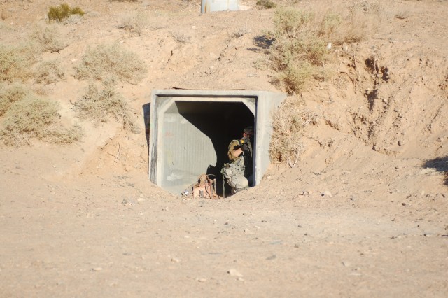 1st Lt. Jeremiah Wertz, a platoon leader in F Troop, 2nd Squadron, 11th Armored Cavalry Regiment fires a M4 carbine in defense of their bunker as part of a training exercise at the National Training C