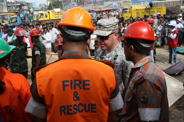 Sgt. 1st. ClassLee speaks with Bangladesh Fire and Civil Defense personnel