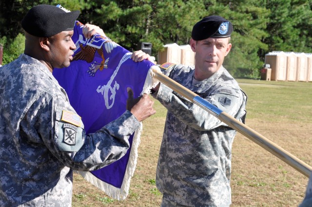 Lt Col William Rice and Cmd Sgt Maj. Devon Lewis unfurl the Battalion colors as a symbol of the unit activation.  The 83rd Civil Affairs Battalion mission is to organize, train, equip and deploy force