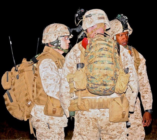 Three Marines from Marine Air Station Yuma discuss operation maneuvers during the training exercise at Fort Huachuca's Libby Airfield on Friday night.