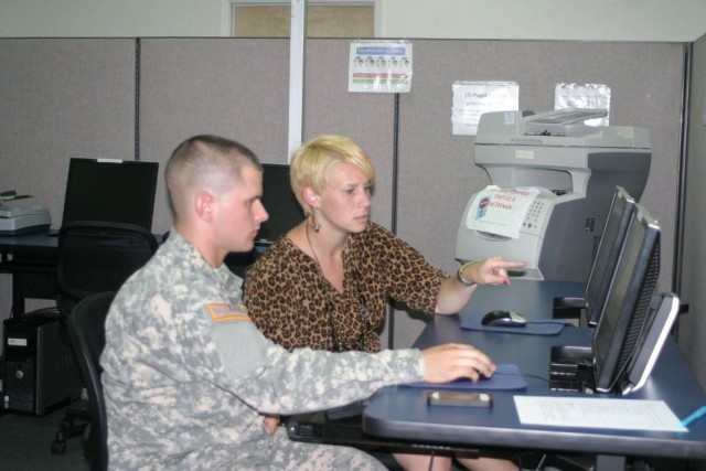 Education Services Specialist Erin Gibson assists Pfc. Orville Arel, Headquarters and Headquarters Company, 40th Theater Tactical Signal Brigade, with setting up tuition assistance online. The Educati