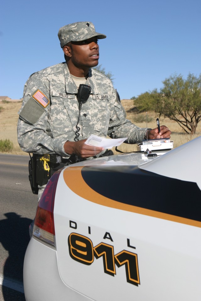 Spc. Daniel Willis, 18th MP Detachment, writes a citation for speeding after stopping a car for traveling 14 miles over the posted speed limit.