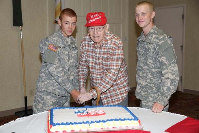 From left, Pvt. Ryan Schluter, 18, Jim Burnett, 94, and Pvt. Jacoby Kellog, 18, cut the cake during the Military Affairs Committee Veterans Day luncheon held at the Thunder Mountain Activity Centre on