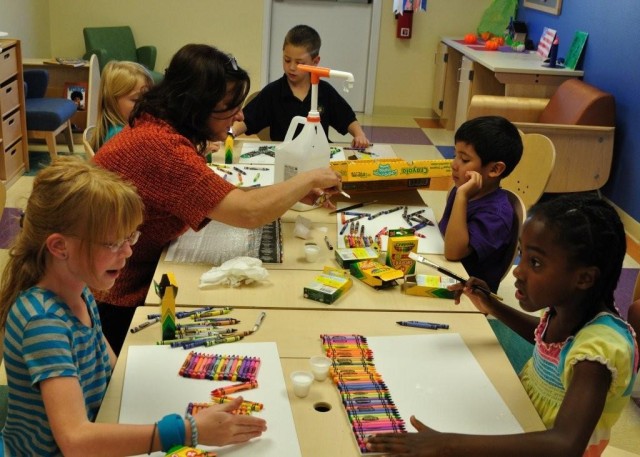Suzanne Crawford, SKIESUnlimited instructional programs specialist, helps students create Melting Crayon Art. Creative Hands classes are offered on Thursdays, 3:30