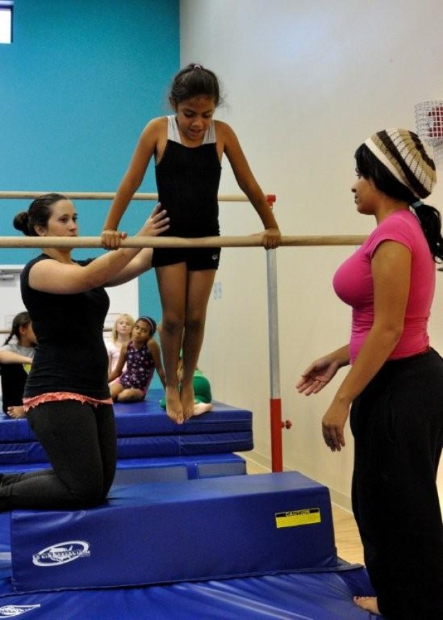 Kelly Montana assists Kayleigh Mitchell, 8, at the handspring machine. Gymnastics classes take place Tuesdays, Wednesdays and Thursdays. For information, call 533.4828.