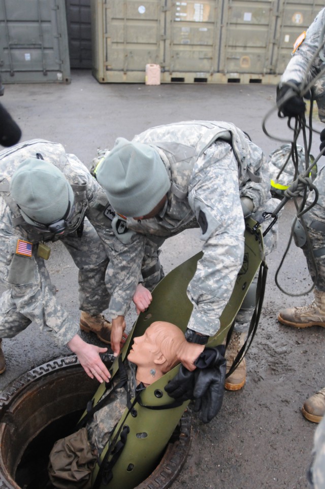 Soldiers pull simulated casualty from storm drain