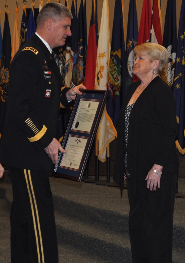 Michelle Campbell, mother of Staff Sgt. Eric Shaw, accepts the Distinguished Service Cross in honor of her son's actions in Afghanistan