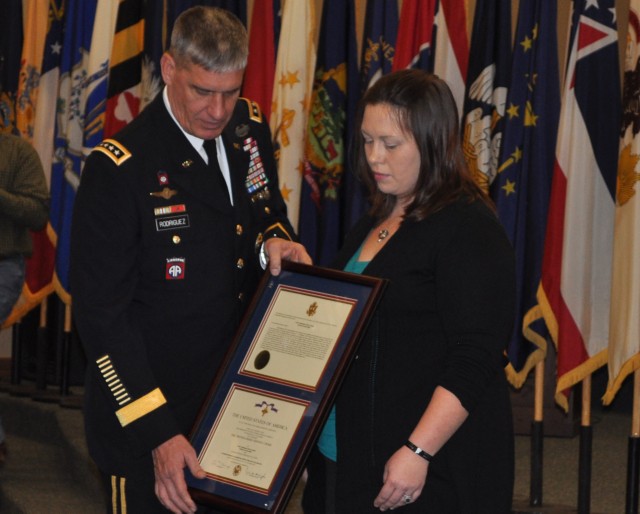 Audrey R. Shaw, widow of Staff Sgt. Eric Shaw, accepts the Distinguished Service Cross in honor of her husband's actions in Afghanistan
