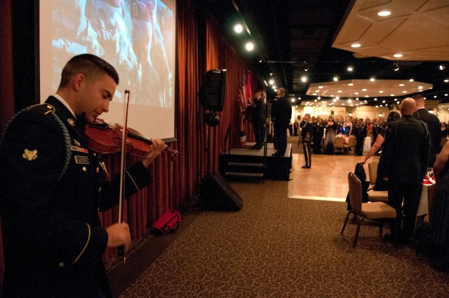 Spc. Ean Ulrich plays a violin for the formal all-ranks ball