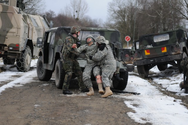 German and American Soldiers carry simulated casualty