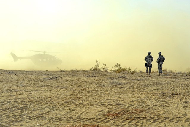 Soldiers watch Kiowa land in DVE