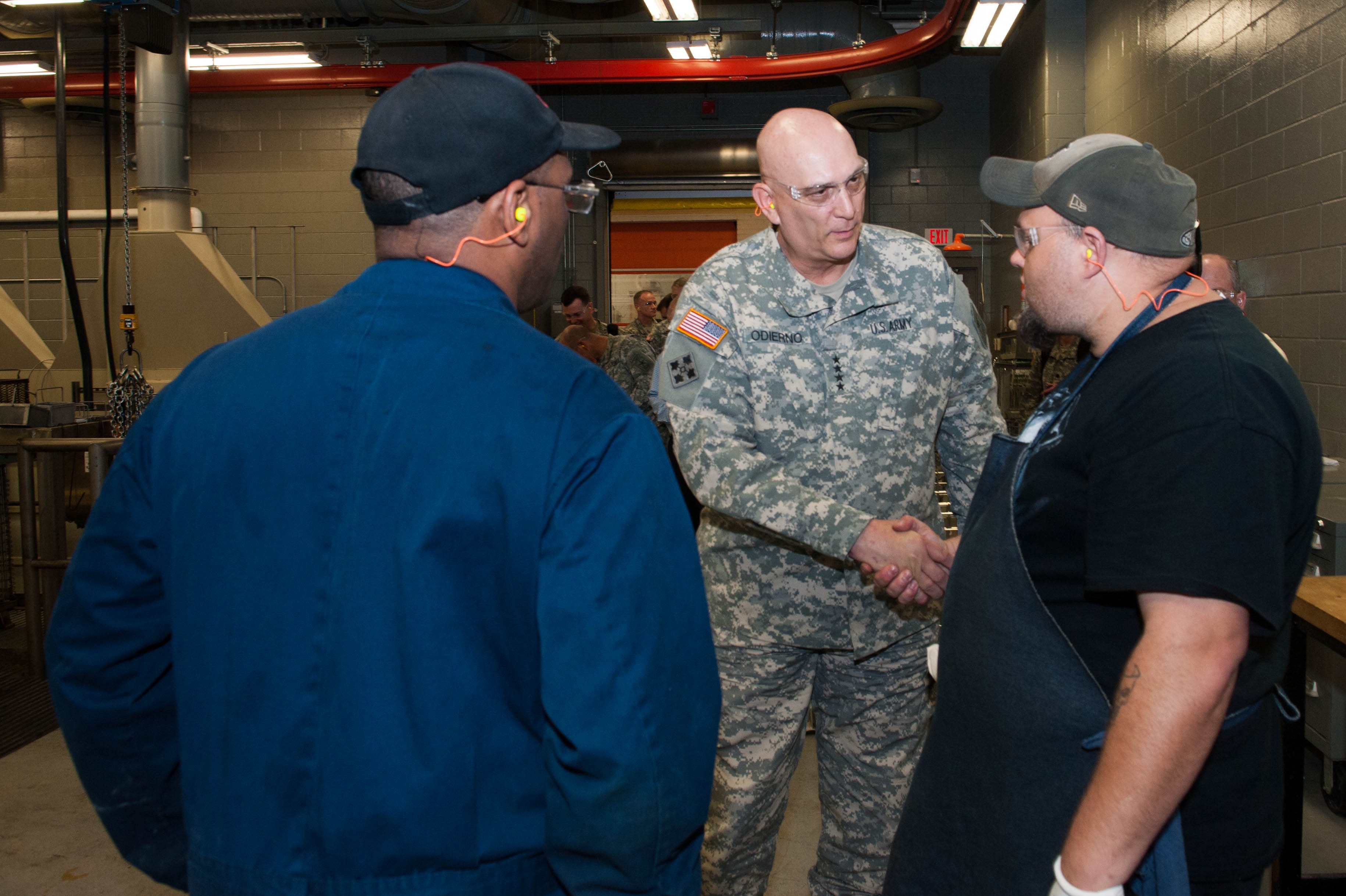 Army Chief of Staff Gen. Raymond T. Odierno prepares to don a Navy football  jersey after