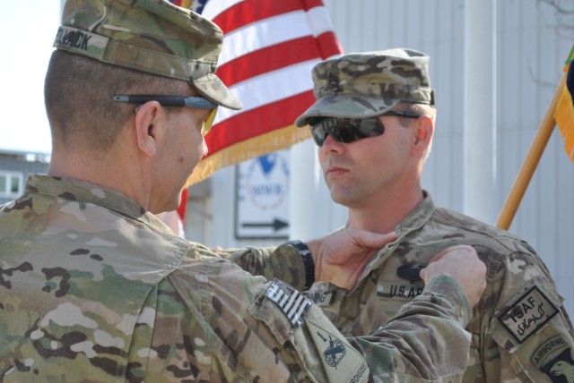 Bastogne Soldier receives Combat Action Badge from his father