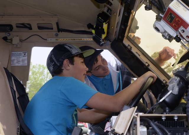 Tristan Randall (left) and Andrew Buck (right) check out the thickness of the windshield glass on a Mine Resistant Ambush Protected vehicle at the Fort A.P. Hill Earth and Safety Day on April 18. Rand