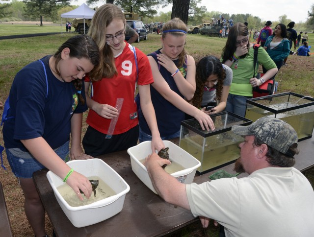 Johnathan Harris, an Aquatic Biologist with the Virginia Department of Game and Inland Fisheries (sitting) brought some turtles, fish and a frog to the Fort A.P. Hill Earth and Safety Day on April 18.