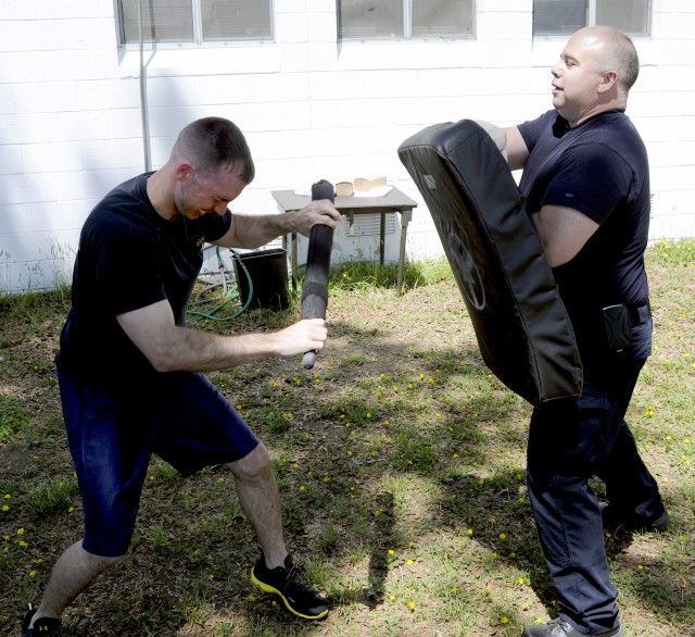 Despite the pepper spray burning his eyes Security guard Joseph Figert (left) had to push back an encroaching person played by Department of the Army police training officer Lt. Ronald Henson.
