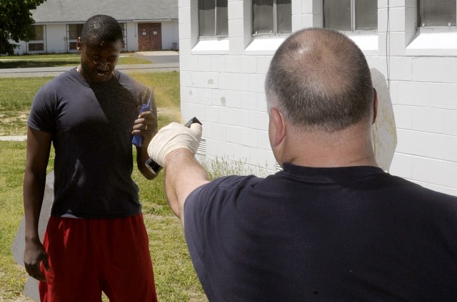 Security guard Shasta Williams (left) had to issue and simulated emergency call after Department of the Army police training officer Lt. Ronald Henson sprayed him with pepper spray.