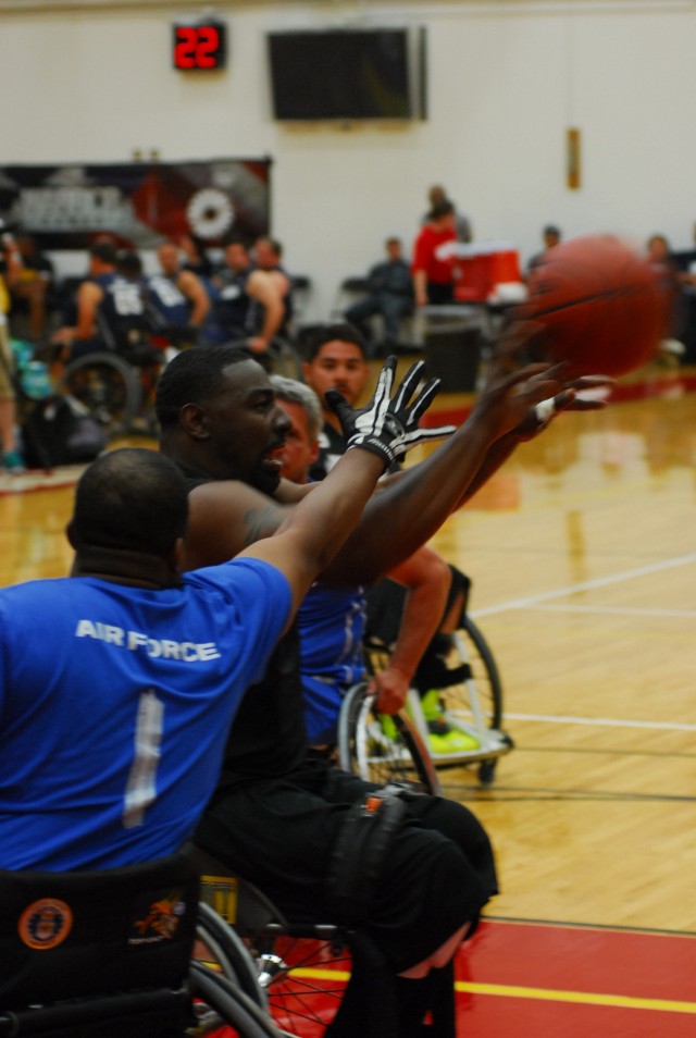 Army veteran and Warrior Games wheelchair basketball athlete passes the ball to a team mate