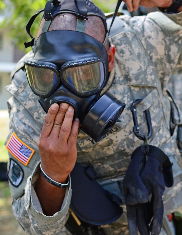 Soldier dons protective mask during training.