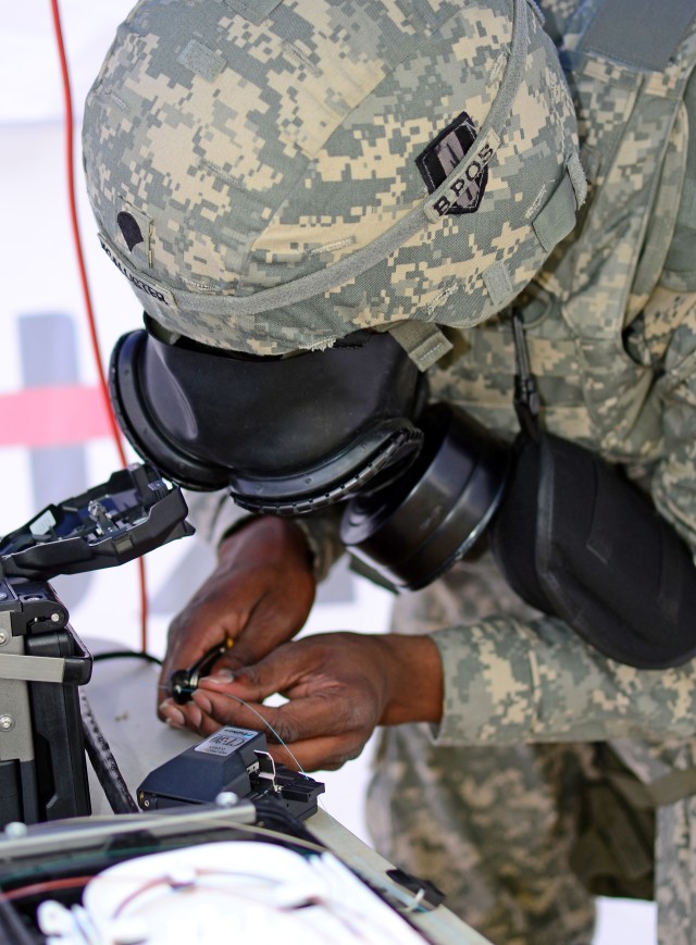 Signal Soldier splices fiber opticable during joint training exercise
