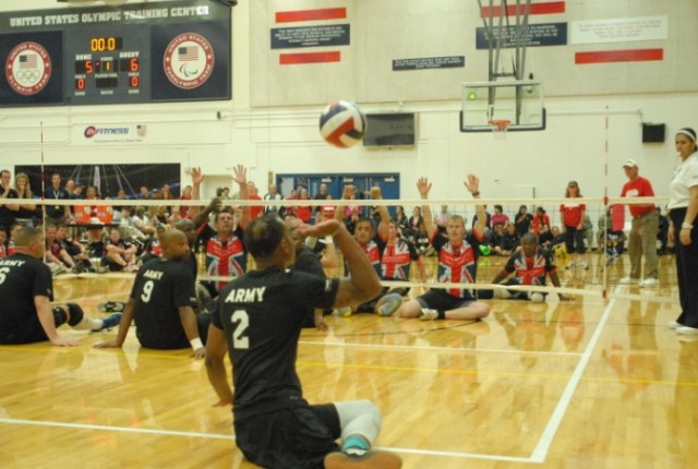 Sgt. Delvin Maston serves the ball during Warrior Games sitting volleyball match