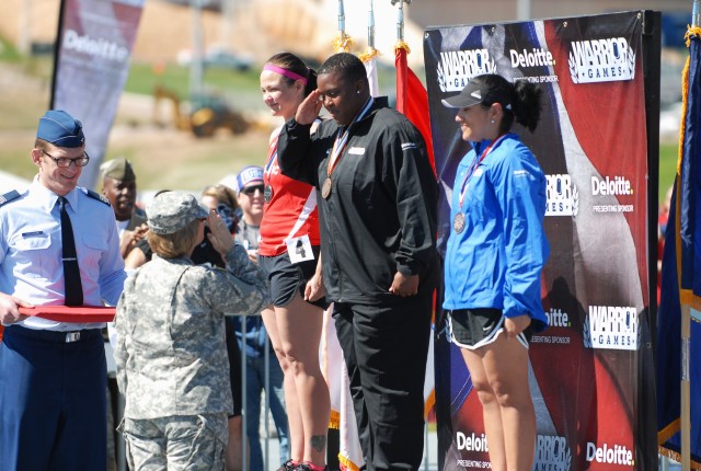 Army Sgt. Monica Southall is salutes Army Surgeon General after winning the women's discuss throw during Warrior Games