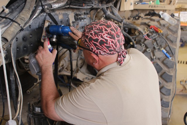 Mechanic drills new mount locations in the frame rail