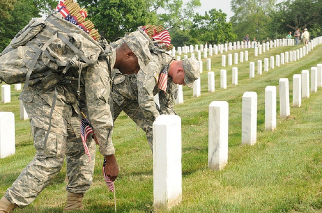 Old Guard Soldiers honor fallen with flags at Arlington graves