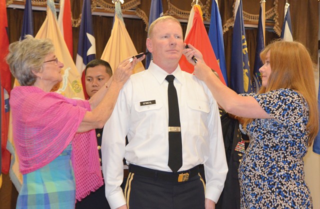 Family members pin on shoulder boards